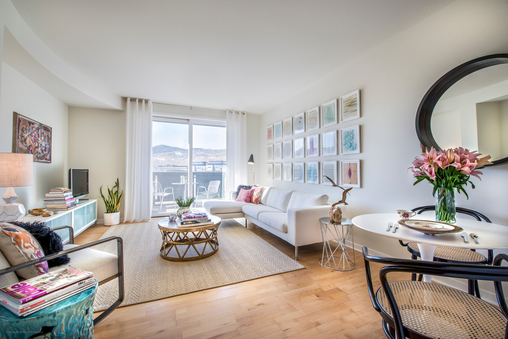 Idee per un soggiorno contemporaneo stile loft e di medie dimensioni con pareti beige, parquet chiaro e TV autoportante