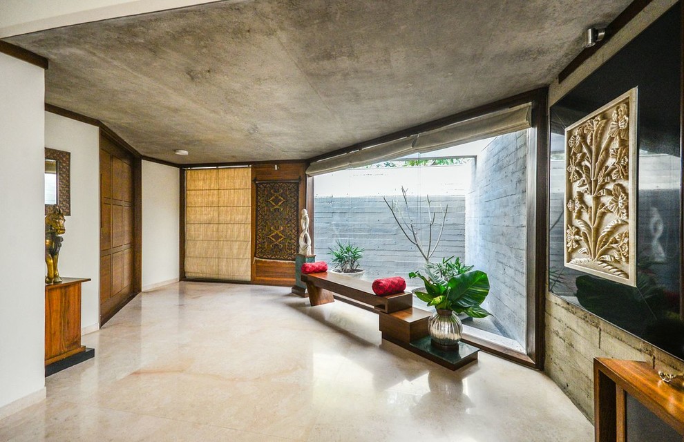 Imagen de sala de estar abierta asiática con paredes blancas, suelo de cemento y suelo gris