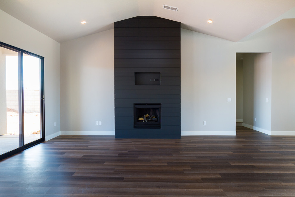Inspiration for a mid-sized contemporary formal and open concept dark wood floor and brown floor living room remodel in Austin with gray walls, a standard fireplace, a plaster fireplace and no tv