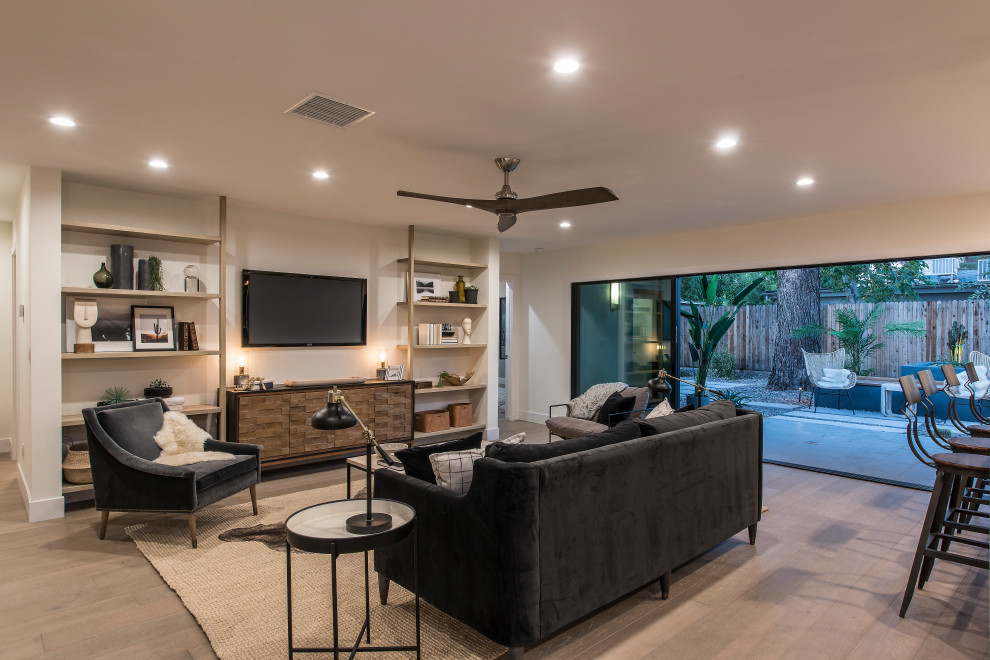 Immagine di un soggiorno minimal aperto con pareti bianche, pavimento in legno massello medio, TV a parete e pavimento marrone