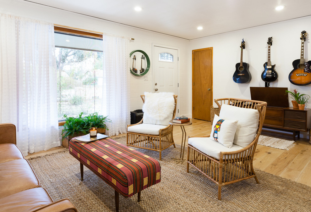 Idée de décoration pour un salon sud-ouest américain ouvert avec un mur blanc, un sol en bois brun et une salle de musique.