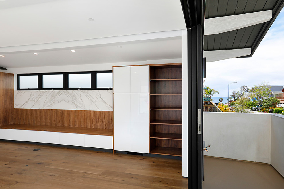 Cette photo montre un salon moderne ouvert avec un mur blanc et un sol en bois brun.