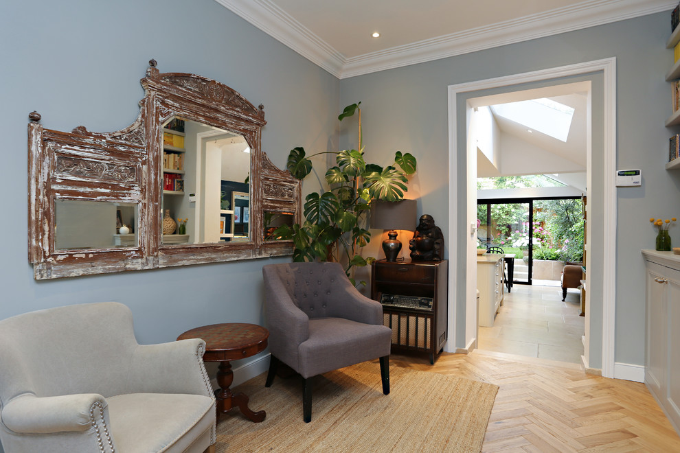 Idée de décoration pour un grand salon bohème ouvert avec une bibliothèque ou un coin lecture, un mur gris, parquet clair, une cheminée standard, un manteau de cheminée en bois, un téléviseur fixé au mur et un sol beige.