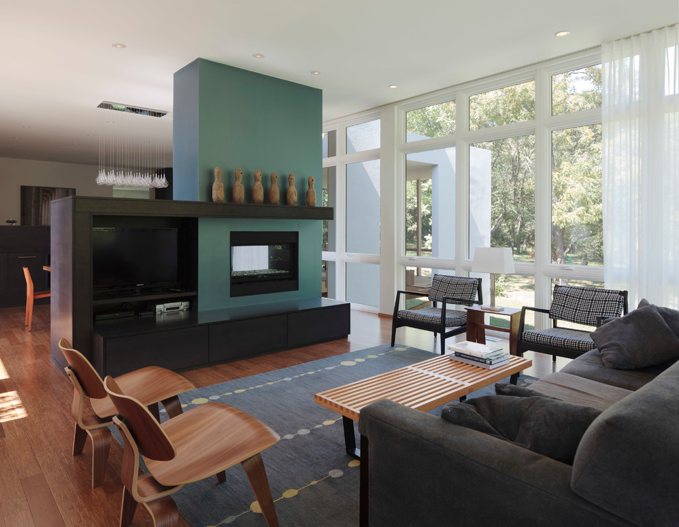 На фото: большая открытая гостиная комната в стиле модернизм с зелеными стенами и ковром на полу с