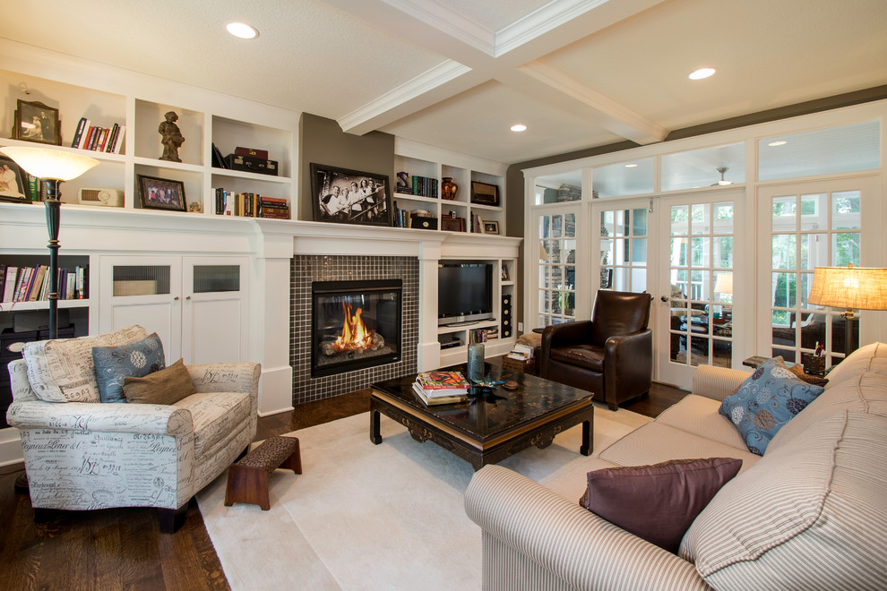 Photo of a medium sized traditional open plan living room in Minneapolis with a tiled fireplace surround, a built-in media unit, medium hardwood flooring and feature lighting.
