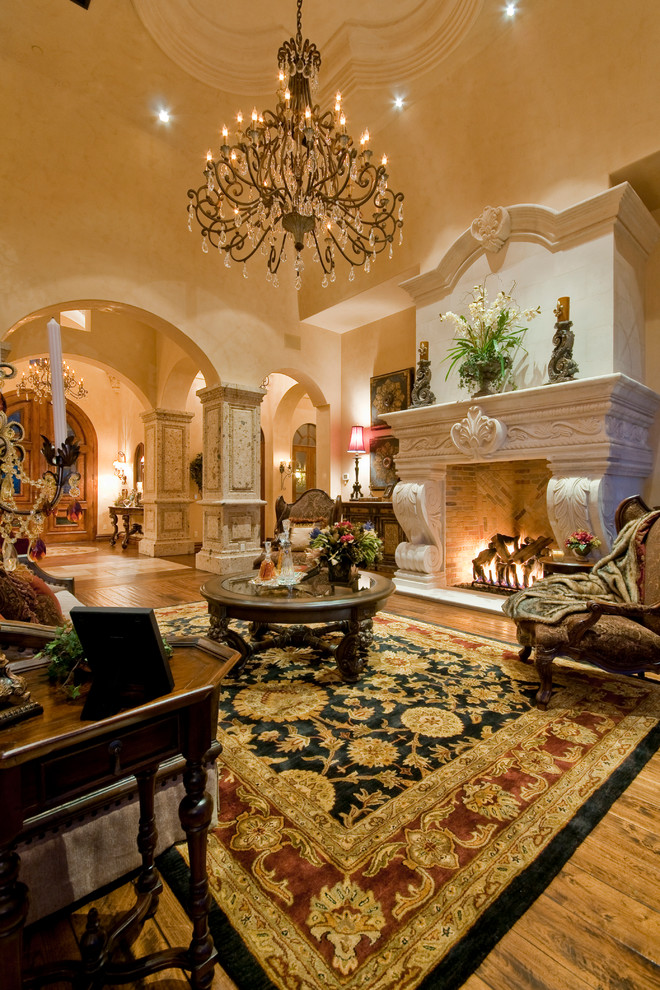 Foto de salón para visitas abierto tradicional extra grande con paredes beige, suelo de madera en tonos medios, todas las chimeneas y marco de chimenea de piedra