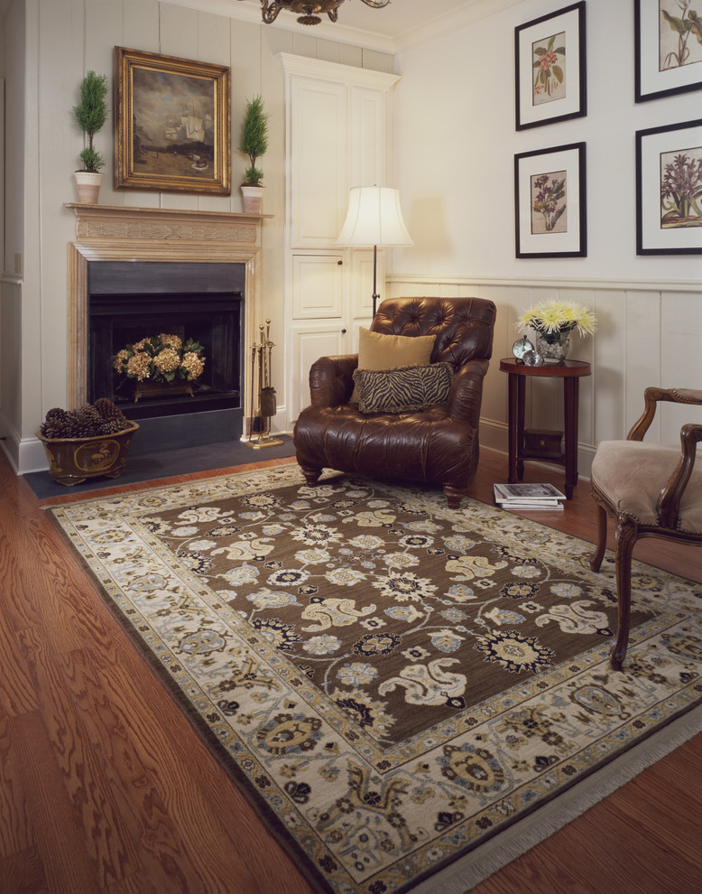 Example of a mid-sized classic enclosed medium tone wood floor living room design in Indianapolis with white walls, a standard fireplace, a plaster fireplace and no tv