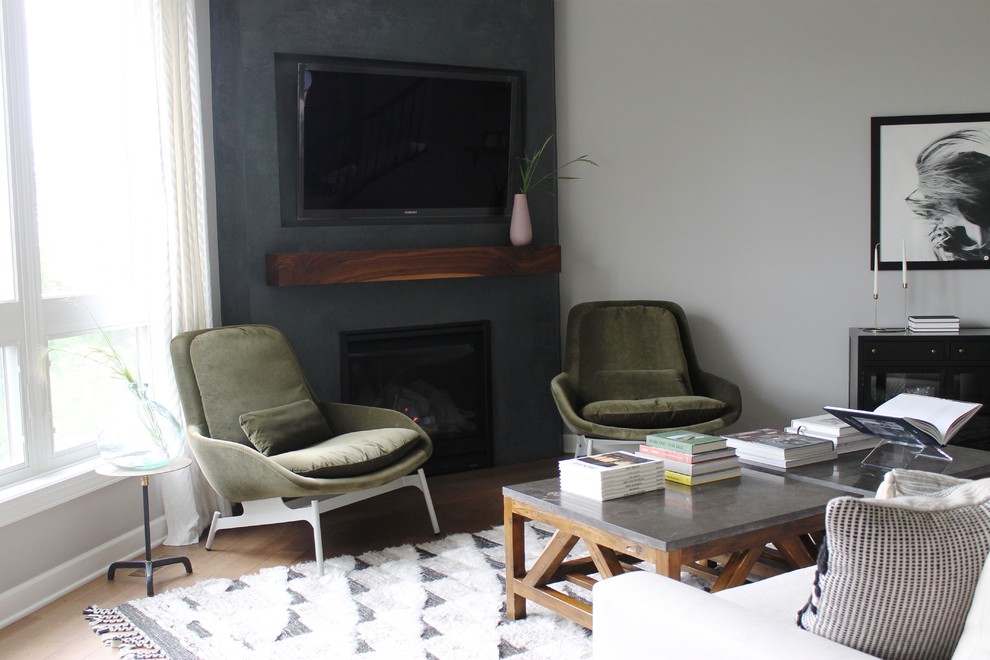 На фото: открытая гостиная комната в стиле ретро с бежевыми стенами, паркетным полом среднего тона, угловым камином, фасадом камина из штукатурки, телевизором на стене и коричневым полом