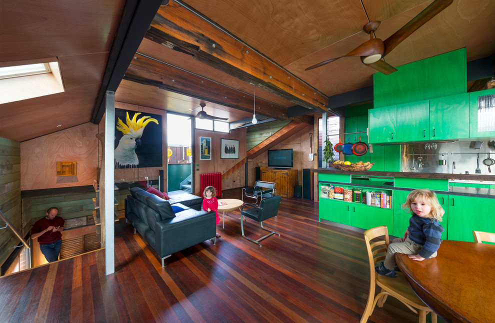 Design ideas for an industrial open plan living room in Melbourne with dark hardwood flooring.