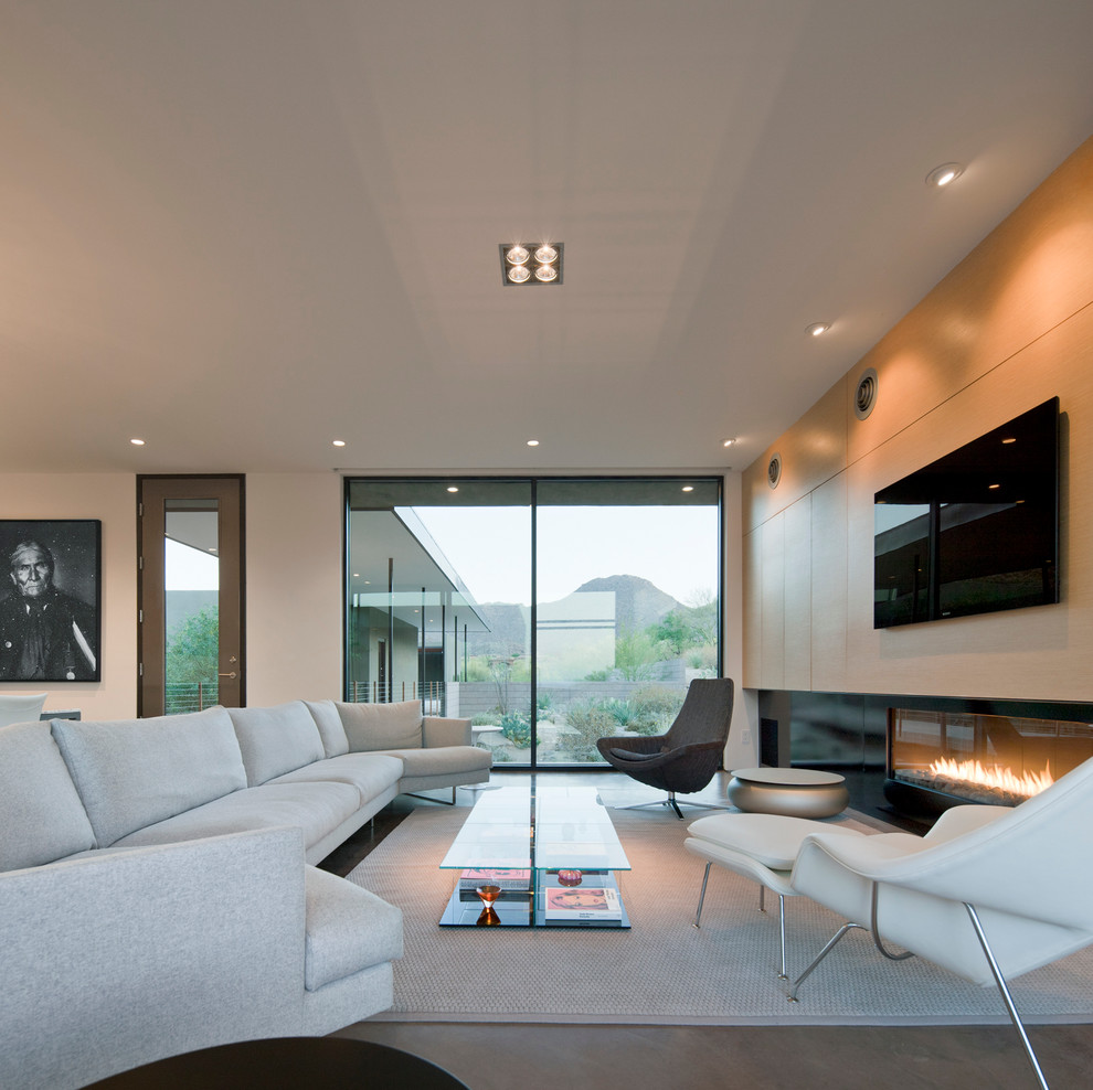 Свежая идея для дизайна: большая открытая гостиная комната в современном стиле с белыми стенами, горизонтальным камином, телевизором на стене, бетонным полом, фасадом камина из металла и серым полом - отличное фото интерьера