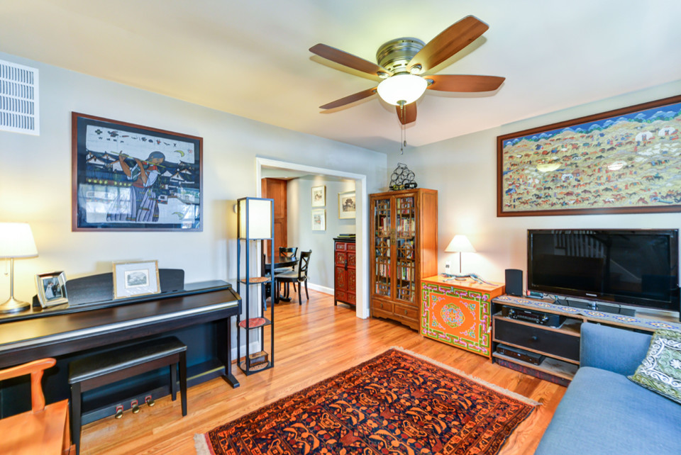 Foto di un piccolo soggiorno classico chiuso con pareti grigie, pavimento in legno massello medio e TV autoportante