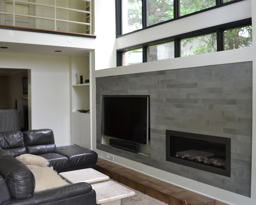 Ejemplo de salón con barra de bar minimalista con paredes grises, todas las chimeneas, marco de chimenea de baldosas y/o azulejos y pared multimedia