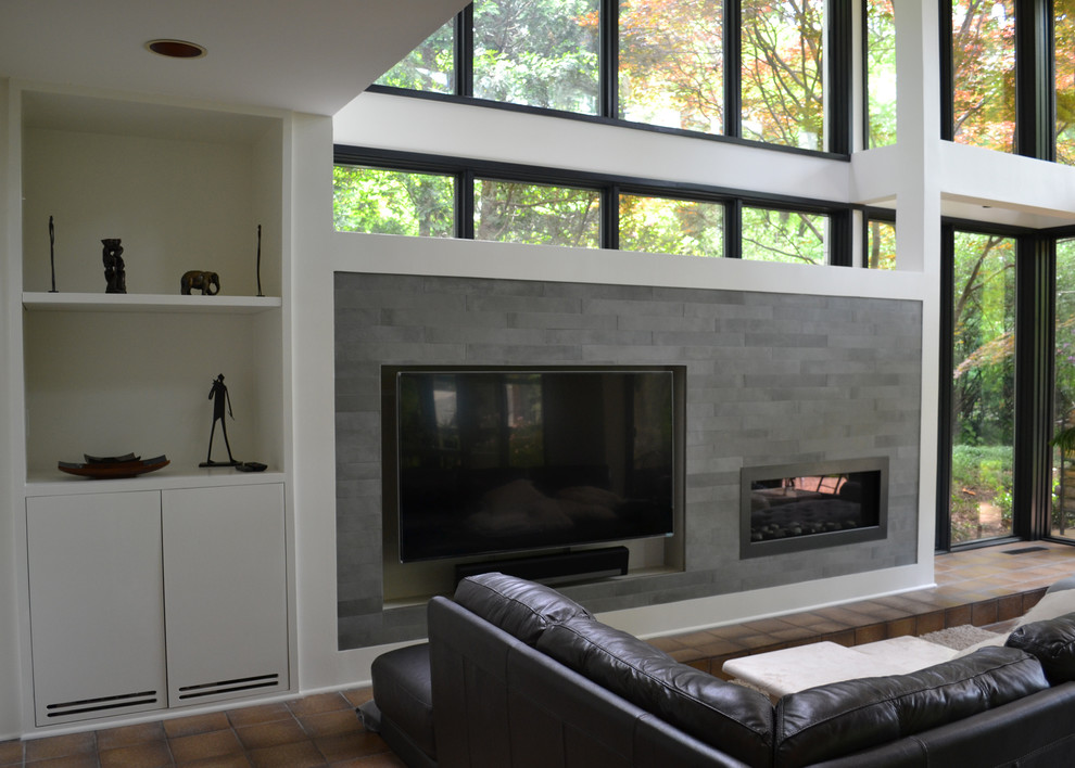 Modern living room in DC Metro with a home bar, grey walls, a standard fireplace, a tiled fireplace surround and a built-in media unit.