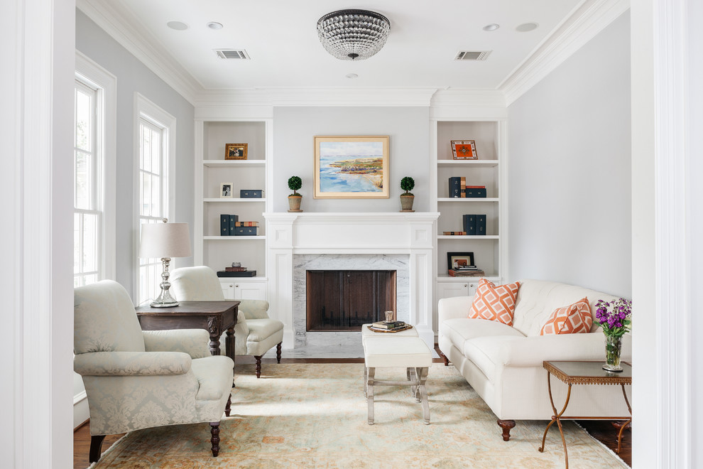 Repräsentatives Klassisches Wohnzimmer mit blauer Wandfarbe, braunem Holzboden, Kamin und Kaminumrandung aus Stein in Houston