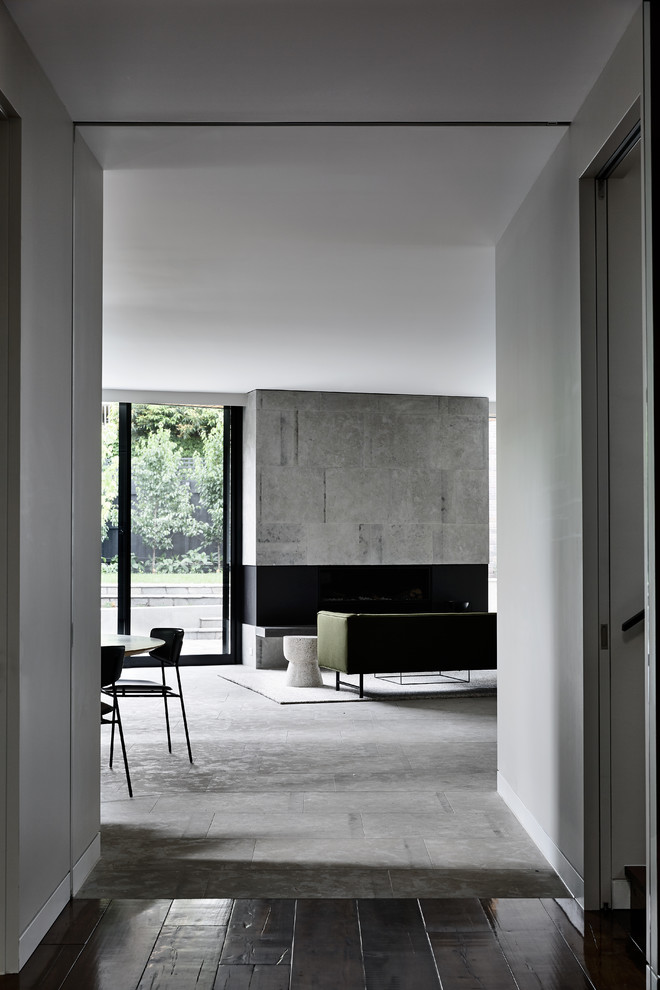 Réalisation d'un grand salon design ouvert avec un mur gris, un sol en ardoise, une cheminée ribbon, un manteau de cheminée en pierre, un téléviseur dissimulé et un sol gris.