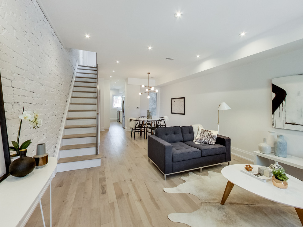 Mittelgroßes, Fernseherloses, Offenes, Repräsentatives Nordisches Wohnzimmer ohne Kamin mit weißer Wandfarbe und hellem Holzboden in Toronto