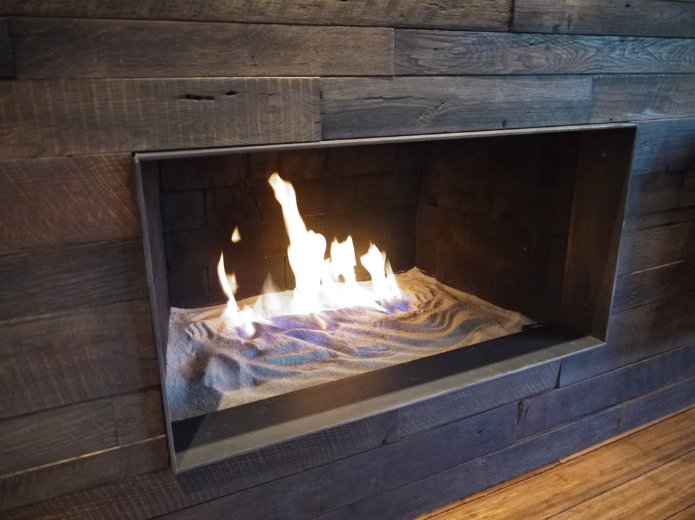 ソルトレイクシティにあるお手頃価格の中くらいなラスティックスタイルのおしゃれなLDK (白い壁、竹フローリング、標準型暖炉、木材の暖炉まわり、壁掛け型テレビ) の写真