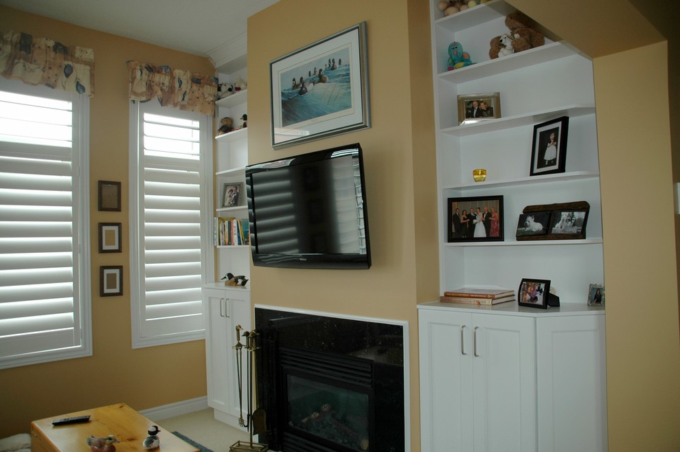 Идея дизайна: двухуровневая гостиная комната среднего размера в классическом стиле с с книжными шкафами и полками, желтыми стенами, ковровым покрытием, стандартным камином, фасадом камина из камня и телевизором на стене