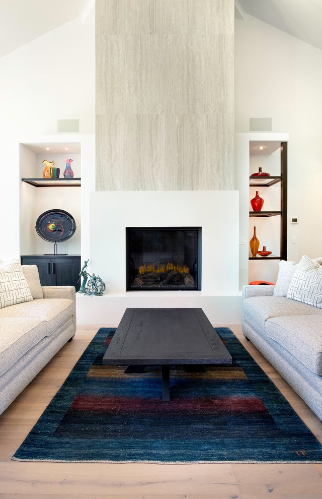На фото: гостиная комната в стиле модернизм с стандартным камином и фасадом камина из плитки