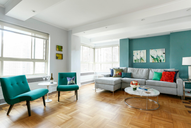 This is an example of a large modern grey and teal open plan living room in New York with green walls, medium hardwood flooring, no fireplace and a wall mounted tv.