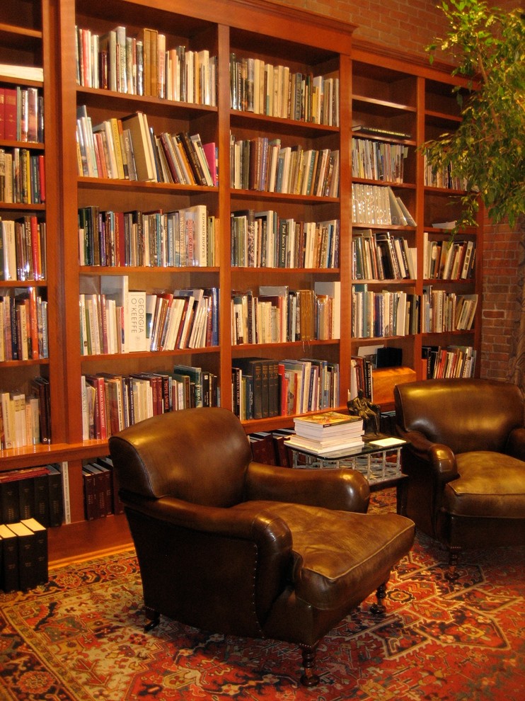 Immagine di un soggiorno classico di medie dimensioni e chiuso con libreria, pareti rosse, parquet scuro, nessun camino, nessuna TV e pavimento marrone
