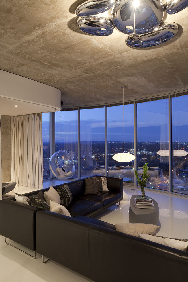 Идея дизайна: огромная открытая гостиная комната в современном стиле с серыми стенами, полом из керамогранита, телевизором на стене и красивыми шторами без камина