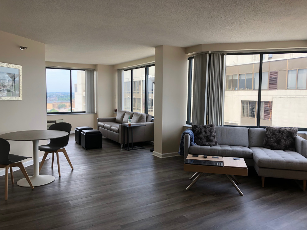 Photo of a medium sized scandinavian open plan living room in Philadelphia with beige walls, medium hardwood flooring, a freestanding tv and grey floors.