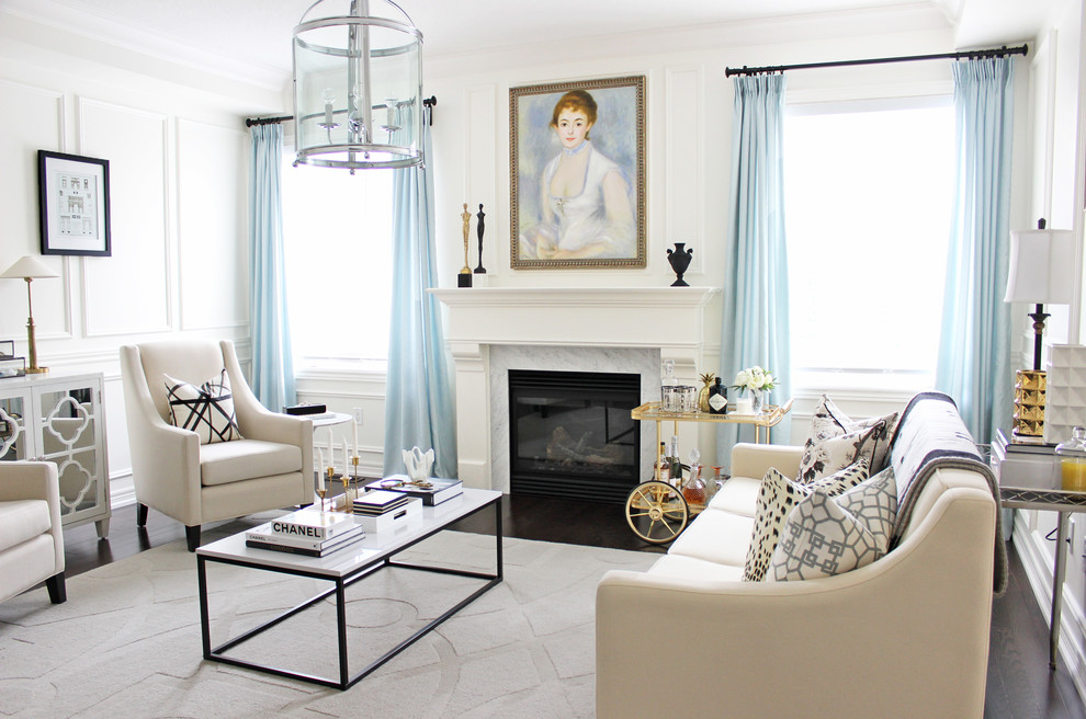 На фото: парадная гостиная комната в стиле неоклассика (современная классика) с белыми стенами, темным паркетным полом, стандартным камином и синими шторами без телевизора