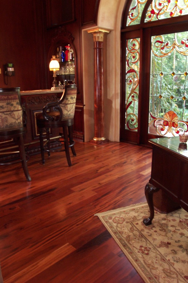 Huge elegant dark wood floor and red floor living room photo in Tampa with a standard fireplace