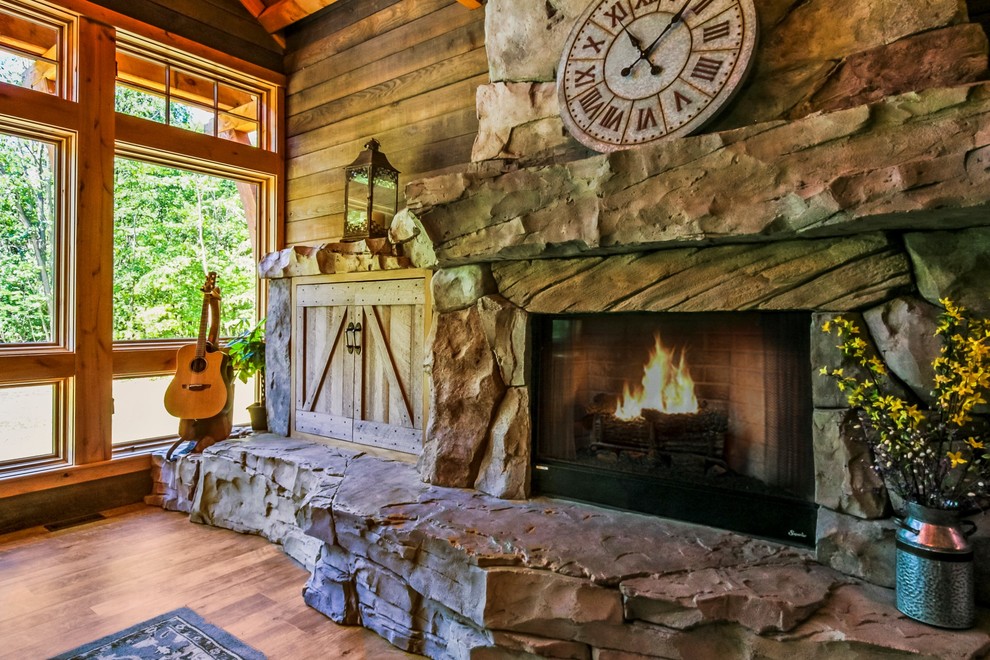 Inspiration for a large rustic open plan living room in Grand Rapids with brown walls, vinyl flooring, a standard fireplace, a concrete fireplace surround, a concealed tv and brown floors.