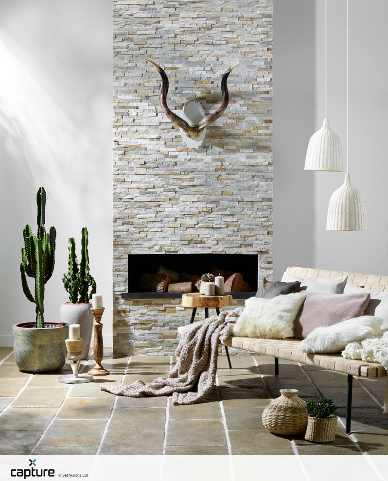 Mediterranes Wohnzimmer mit weißer Wandfarbe, Travertin und Kamin in Sonstige