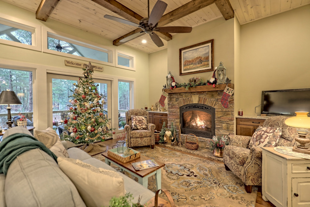 Example of a large arts and crafts formal and open concept medium tone wood floor, brown floor and exposed beam living room design in Atlanta with green walls, a standard fireplace, a stone fireplace and no tv
