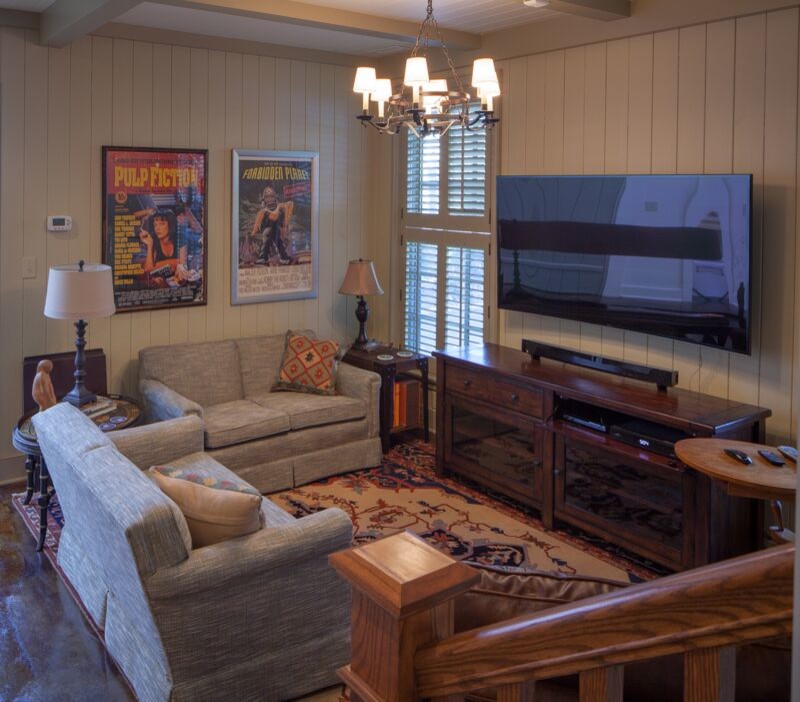 Modelo de salón con rincón musical cerrado de tamaño medio con paredes beige y televisor colgado en la pared