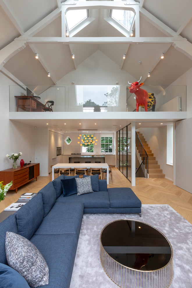 Photo of a medium sized contemporary mezzanine living room in London with white walls, light hardwood flooring and beige floors.