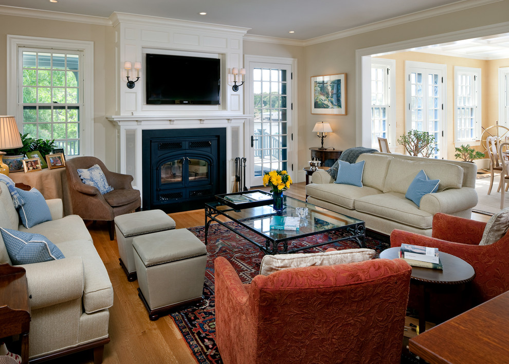 Mittelgroßes, Repräsentatives, Offenes Klassisches Wohnzimmer mit beiger Wandfarbe, braunem Holzboden, Kaminofen, Kaminumrandung aus Metall und TV-Wand in Boston