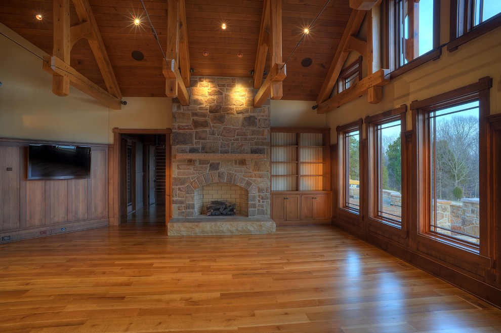 Traditional mezzanine living room in Other with light hardwood flooring, a standard fireplace, a stone fireplace surround and a wall mounted tv.