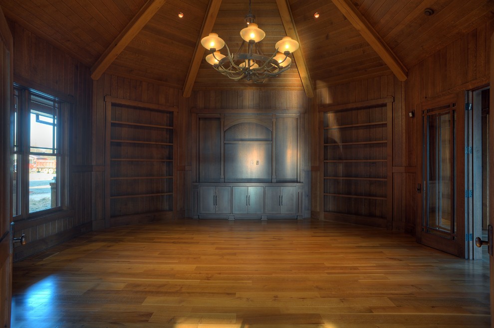 Foto di un soggiorno american style aperto con libreria e pavimento in legno massello medio