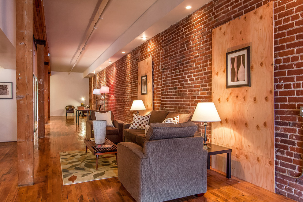 Offenes, Kleines, Repräsentatives, Fernseherloses Industrial Wohnzimmer ohne Kamin mit braunem Holzboden und roter Wandfarbe in Los Angeles