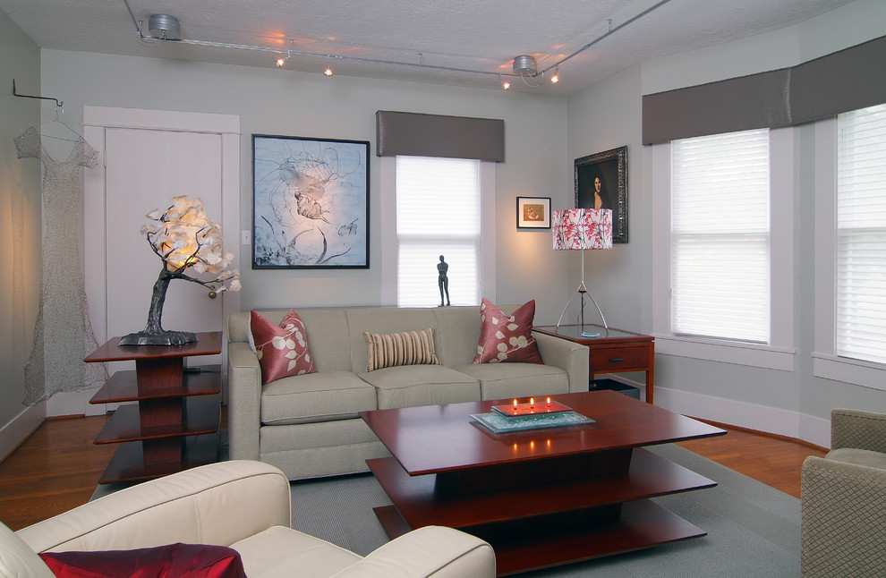 Стильный дизайн: изолированная гостиная комната среднего размера в стиле неоклассика (современная классика) с серыми стенами, паркетным полом среднего тона, стандартным камином и фасадом камина из кирпича без телевизора - последний тренд
