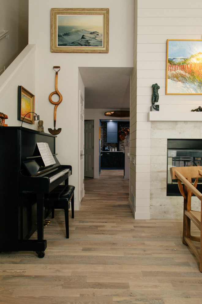 Inspiration for a small coastal open concept light wood floor, white floor, vaulted ceiling and shiplap wall living room remodel in Denver with a music area, white walls, a two-sided fireplace, a wood fireplace surround and a wall-mounted tv
