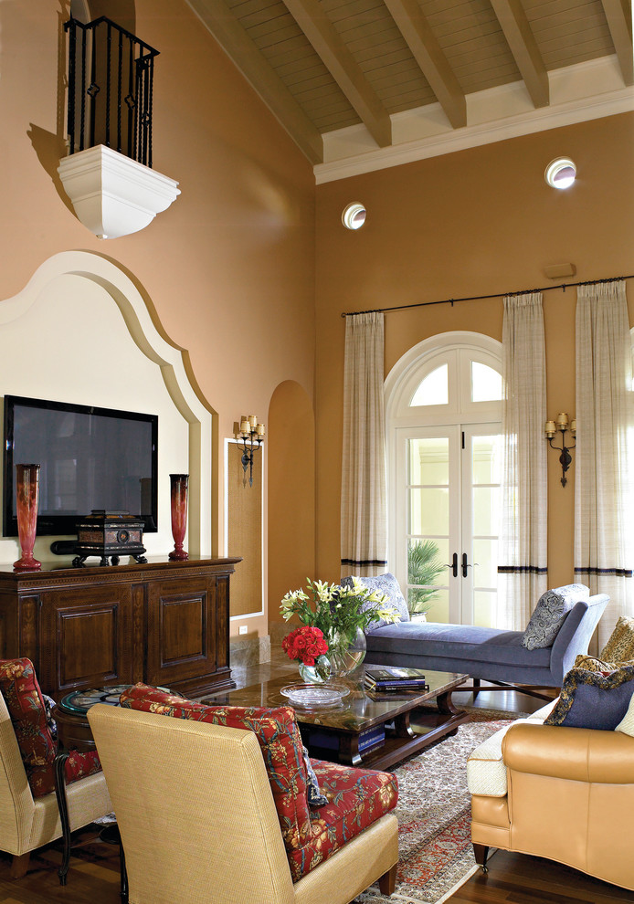Источник вдохновения для домашнего уюта: парадная гостиная комната в средиземноморском стиле с коричневыми стенами, темным паркетным полом и телевизором на стене