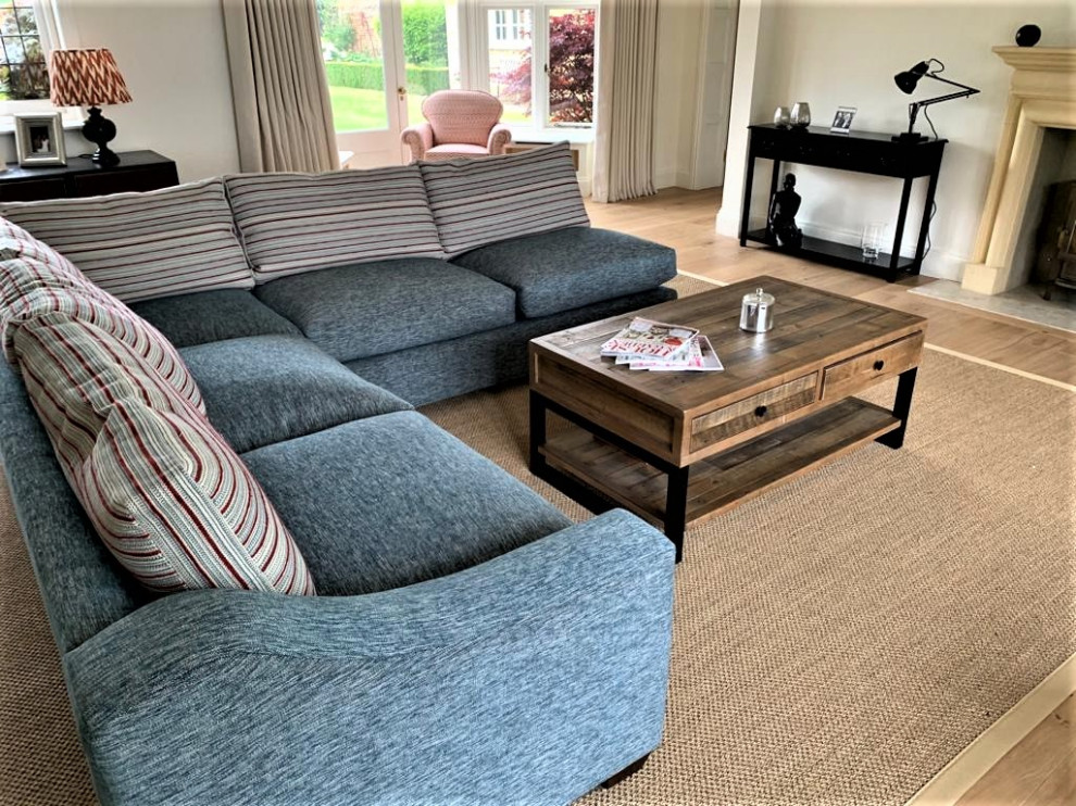 Large contemporary open plan living room in Hertfordshire with white walls, a standard fireplace and a wooden fireplace surround.