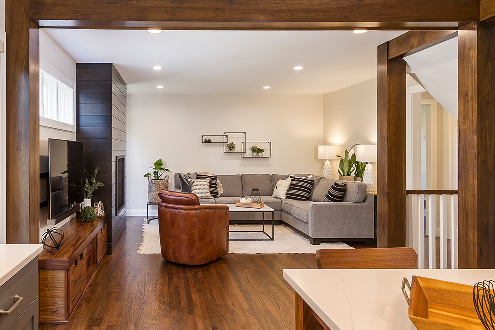 Mittelgroßes, Offenes Klassisches Wohnzimmer mit weißer Wandfarbe, braunem Holzboden, Kamin, Kaminumrandung aus Holz und TV-Wand in Minneapolis