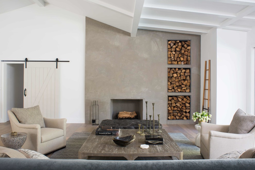 Aménagement d'un grand salon campagne ouvert avec un mur blanc, parquet clair, une cheminée standard et un manteau de cheminée en béton.