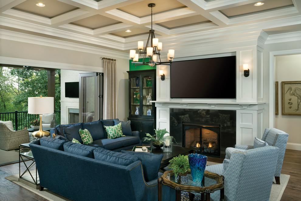 Offenes, Großes Klassisches Wohnzimmer mit grauer Wandfarbe, dunklem Holzboden, Kamin, Kaminumrandung aus Stein und TV-Wand in Cincinnati