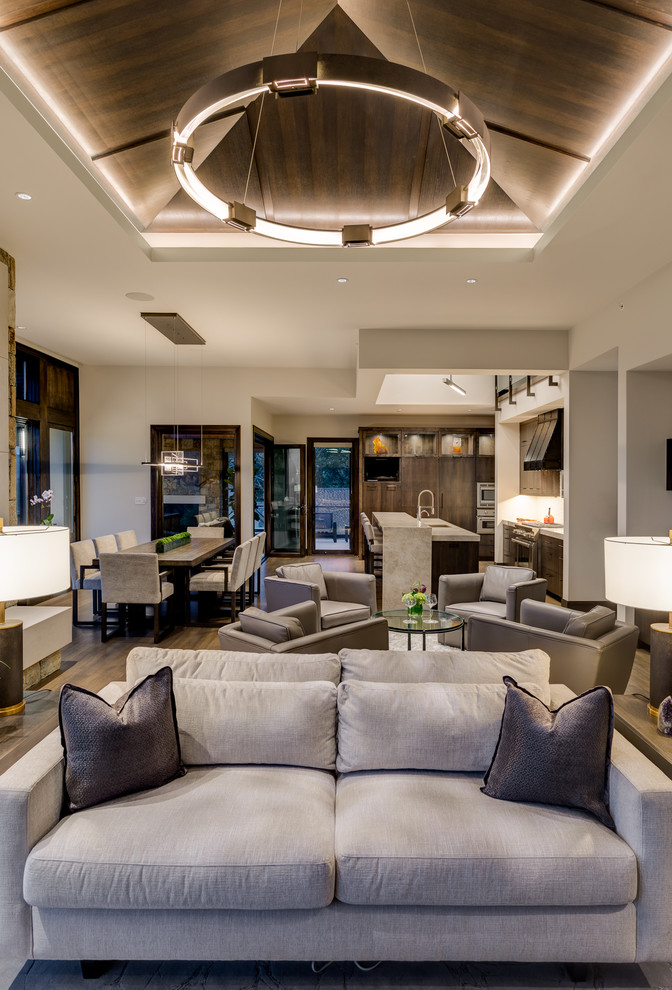 Стильный дизайн: открытая гостиная комната в стиле рустика с белыми стенами, паркетным полом среднего тона и коричневым полом - последний тренд