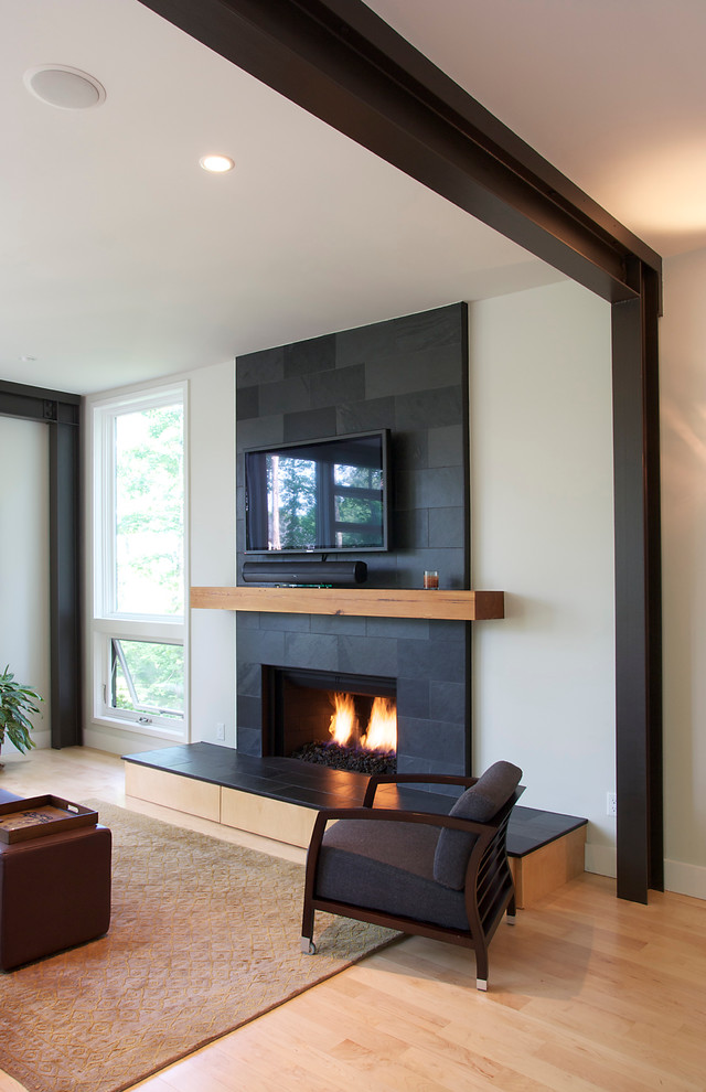 リッチモンドにある高級な広いコンテンポラリースタイルのおしゃれなLDK (ベージュの壁、淡色無垢フローリング、標準型暖炉、タイルの暖炉まわり、壁掛け型テレビ) の写真