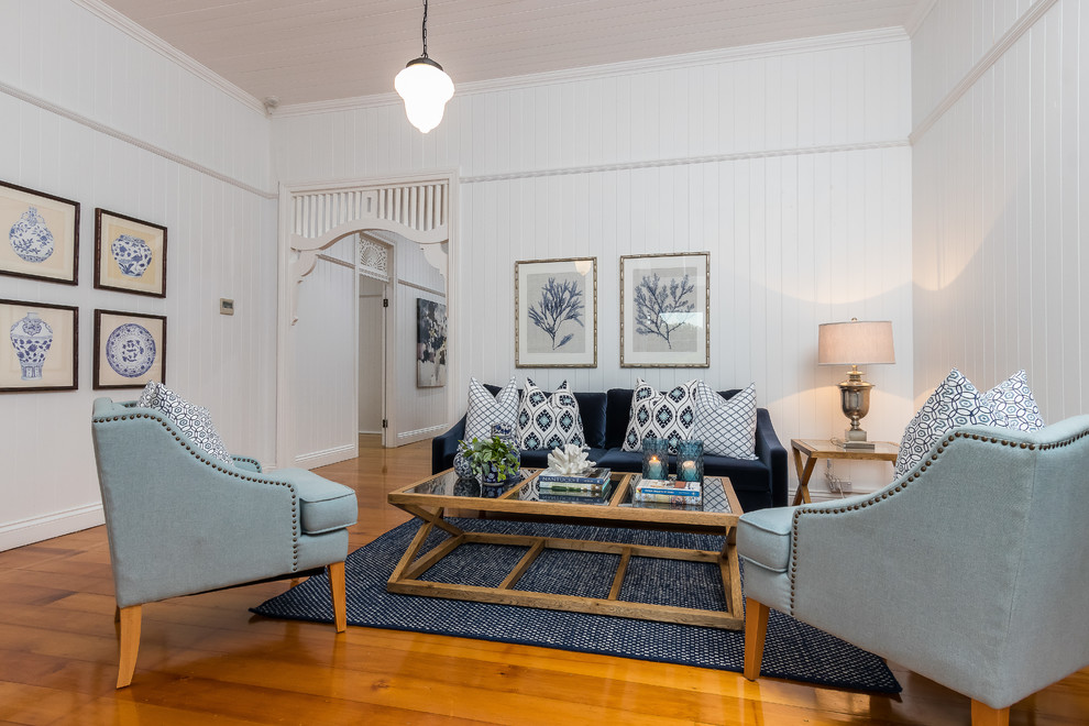 Стильный дизайн: изолированная гостиная комната в морском стиле с белыми стенами, паркетным полом среднего тона и коричневым полом - последний тренд