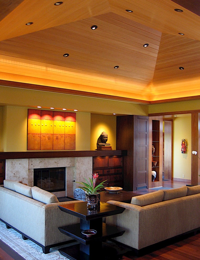 Idées déco pour un grand salon contemporain ouvert avec un mur jaune, un sol en bois brun, une cheminée standard, un manteau de cheminée en pierre et un téléviseur dissimulé.