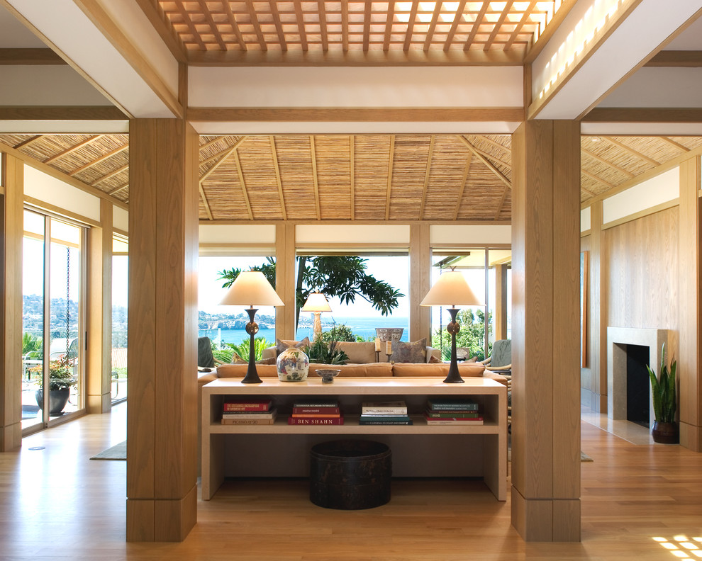 Offenes Asiatisches Wohnzimmer mit hellem Holzboden und Kamin in San Diego
